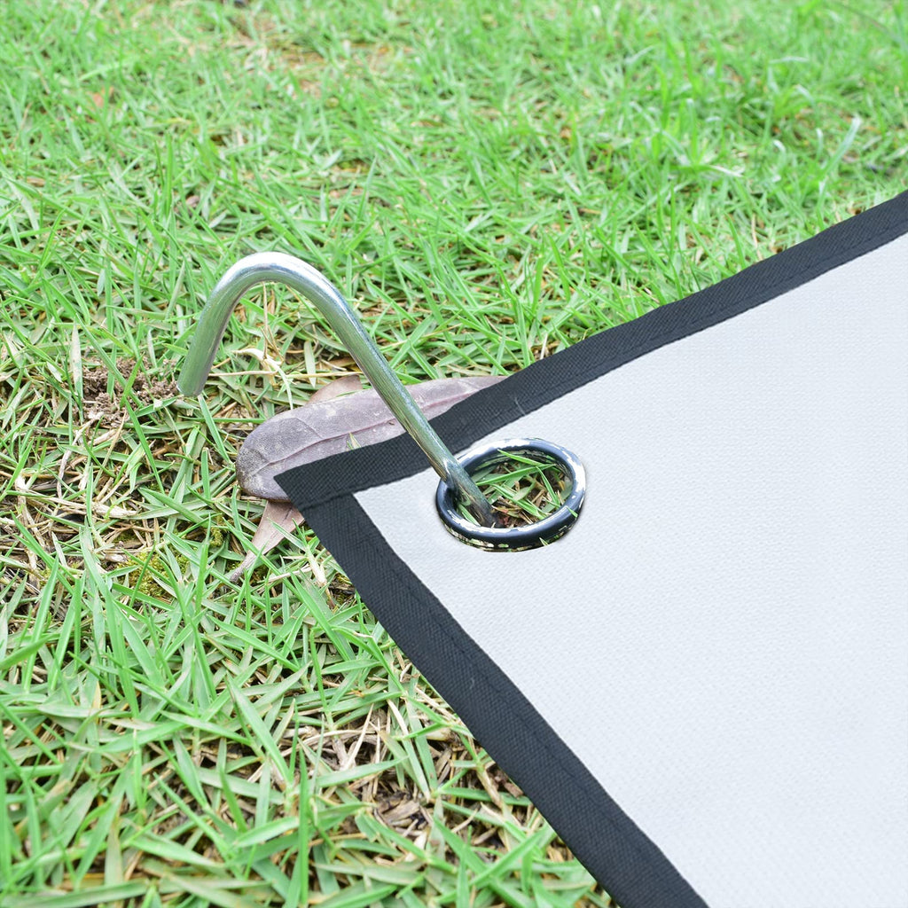 Securing a canopy leg to the ground using a 9-inch metal tent stake in sandy soil at a campsite